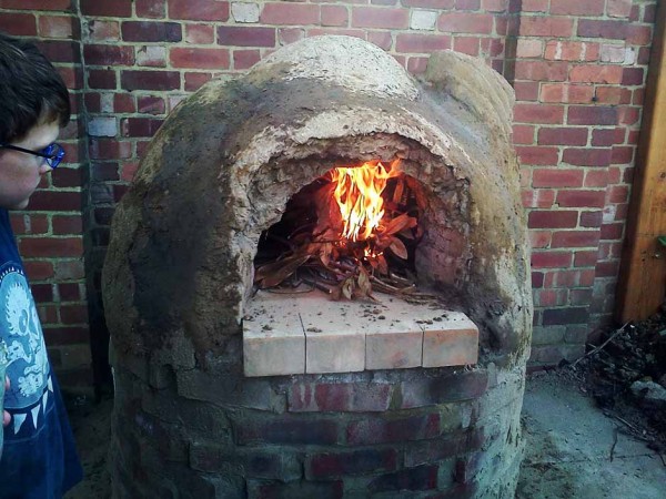 A cob oven burning brightly.